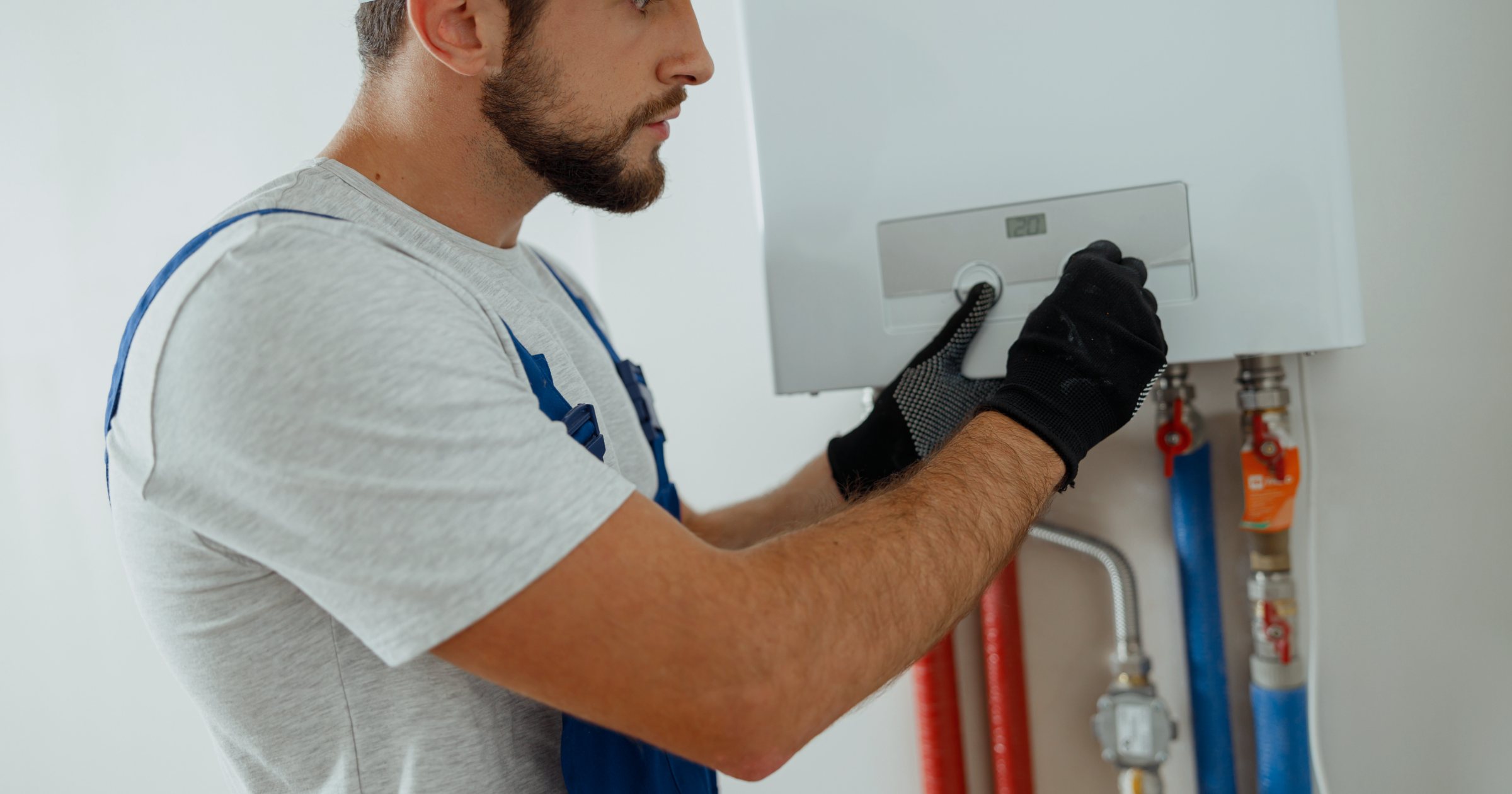 Tehnician verificând o centrală termică pe gaz montată pe perete