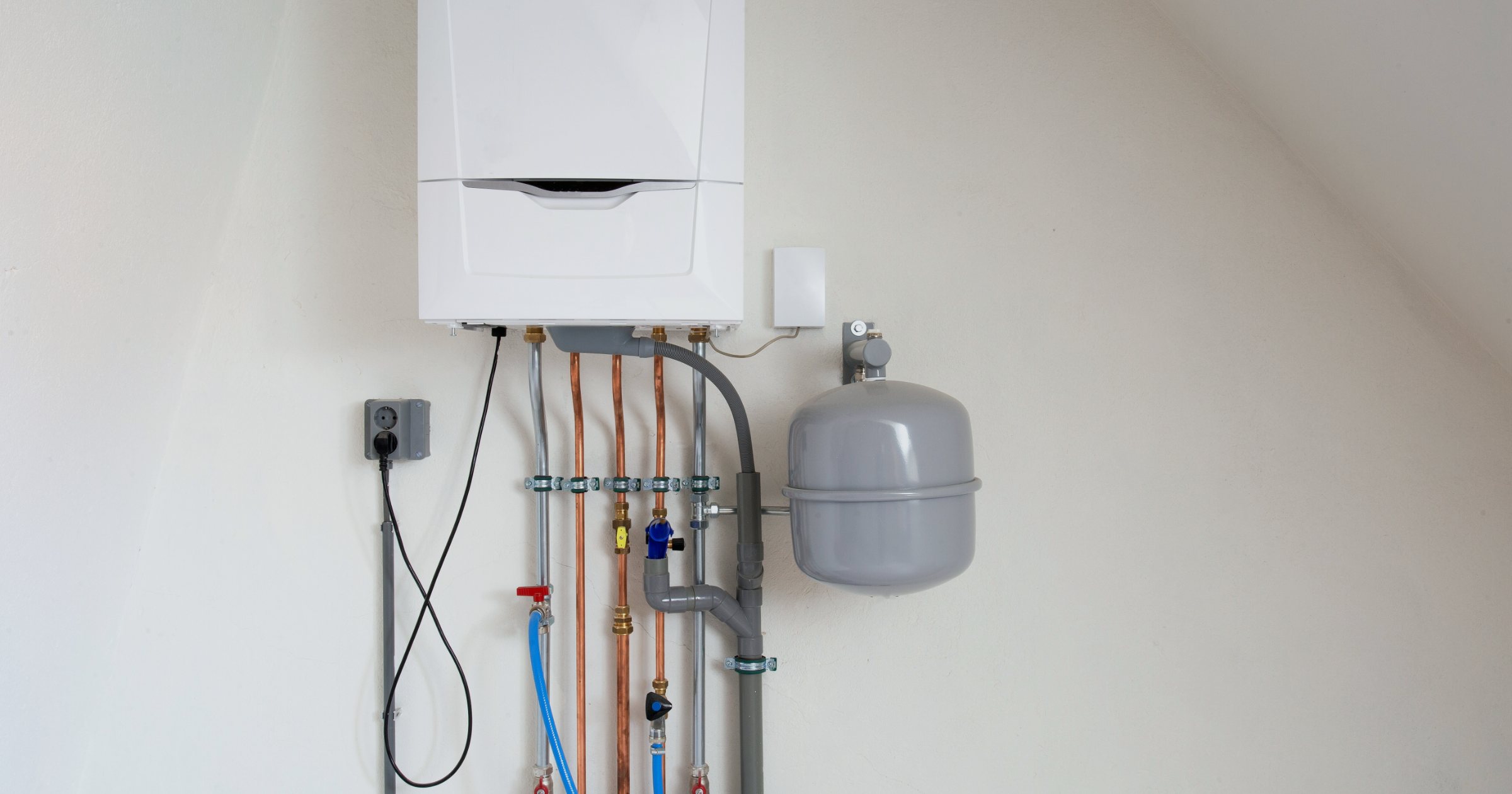 Centrală termică pe gaz montată pe perete, cu țevi de cupru, robinete și vas de expansiune într-o cameră tehnică modernă